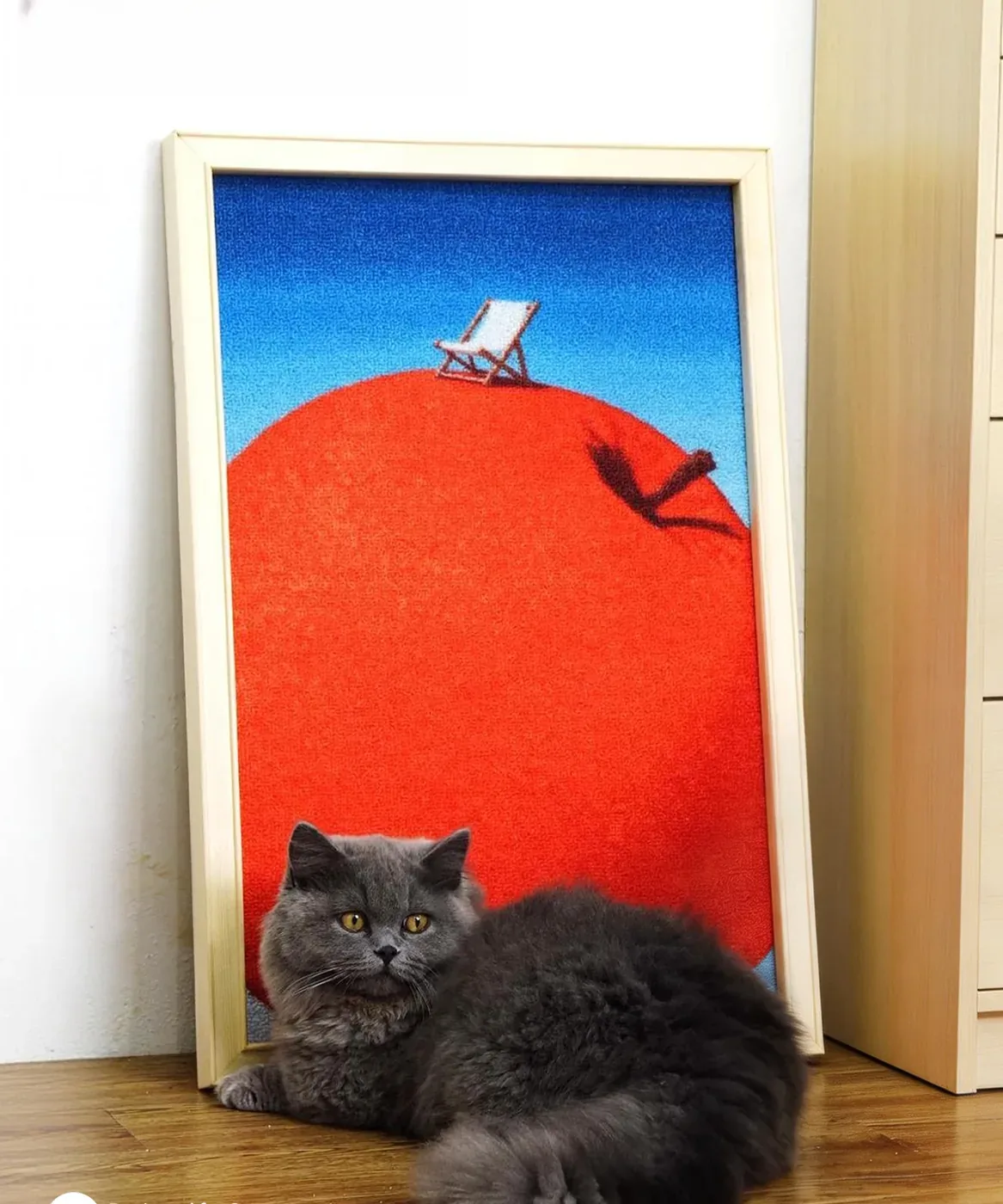 A grey cat lying beside the Red Fruit canvas